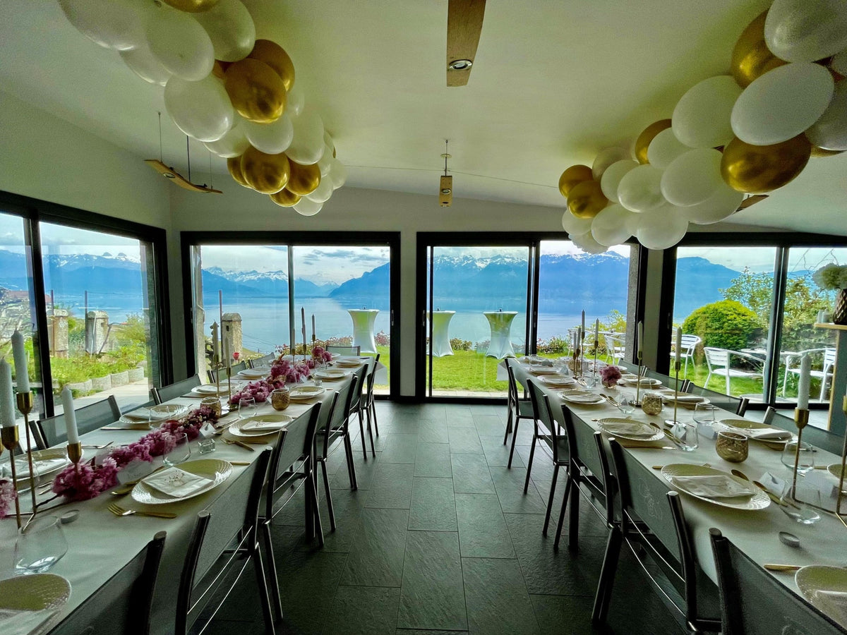 La Véranda Francey Vins décorée pour un événement privé, avec tables dressées, ballons et vue sur le lac Léman.